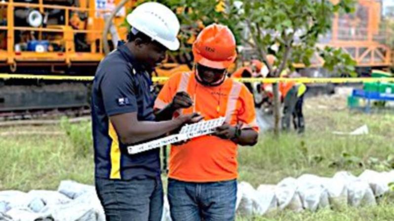 Castle Minerals geologists examining a tray of drill chips from the company’s Wa gold project that sits in the West African country of Ghana.