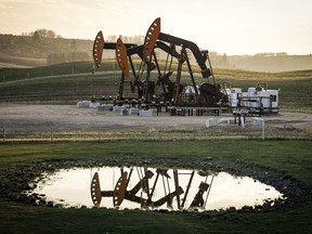 Pumpjacks draw out oil and gas from well heads as wildfire smoke hangs in the air near Calgary, Alta., Sunday, May 12, 2024.