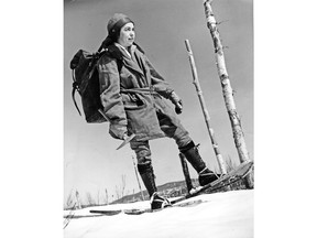 Viola MacMillan, woman prospector and mine developer, is seen in the 1920s with a rock pick, backpack and snowshoes